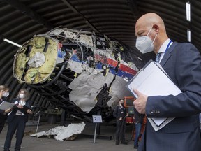FILE - Presiding judge Hendrik Steenhuis, right, and other trial judges and lawyers view the reconstructed wreckage of Malaysia Airlines Flight MH17, at the Gilze-Rijen military airbase, southern Netherlands, Wednesday, May 26, 2021. A Russian suspect in the 2014 downing of Malaysia Airlines flight MH17 over eastern Ukraine appealed in a video statement to a Dutch court on Friday, June 10, 2022 to be declared innocent, as judges adjourned the long-running trial of three Russians and a Ukrainian separatist rebel and began months of deliberations to reach verdicts.