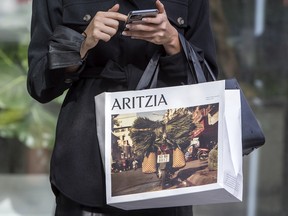A woman with an Aritzia shopping bag in Toronto.