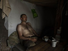 A Ukrainian serviceman takes a break after digging trenches near the frontline in Donetsk region, eastern Ukraine, Wednesday, June 8, 2022.