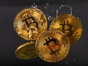 Souvenir tokens representing cryptocurrency Bitcoin plunge into water.