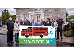 Firefighters and city officials pose with a drawing of their all-electric Vector™ Rescue Decon truck for the City of Varennes Fire Safety Service in Quebec; the first Rescue truck using the first fully electric North America- style fire truck design.