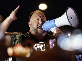 FILE - Infowars host and conspiracy theorist Alex Jones rallies pro-Trump supporters outside the Maricopa County Recorder's Office, on Nov. 5, 2020, in Phoenix, Ariz. A federal judge in Texas has dismissed the bankruptcy protection case of Infowars and two other companies controlled by Alex Jones. The ruling on Friday, June 10, 2022, was the result of an agreement between lawyers for the conspiracy theorist and parents of some of the children slain in the 2012 Sandy Hook Elementary School shooting.