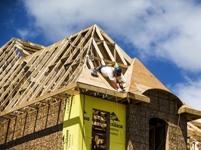 A construction worker works on a new house being built in a suburb located north of Toronto in Vaughan, Ont.