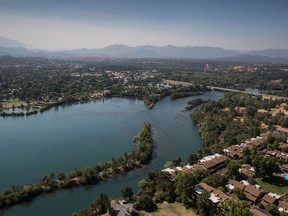 The Sacramento River flows through the downtown area as viewed on a smoky afternoon on August 4, 2021, near Redding, California.