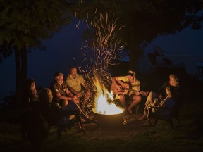 The Hanavan family and friends enjoy a camp fire on the shore of Shadow Lake near Coboconk, Ont., Saturday, Aug. 8, 2021. Though health restrictions have lifted, some summer camp operators say they're grappling with staffing issues related to the COVID-19 pandemic.