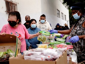 distribuer des colis d'aide aux personnes en situation d'insécurité alimentaire lors d'une distribution de nourriture et de lait maternisé à San Diego, en Californie.