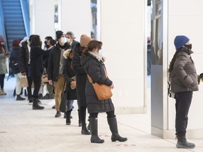 People wait in line to enter a clothing store in a shopping mall in Montreal, Saturday, January 15, 2022, as the COVID-19 pandemic continues in Canada. Statistics Canada has updated the basket of goods it uses to calculate its consumer price index and inflation. The agency says the the basket weights have been updated to reflect the relative importance of the goods and services bought by Canadian households, based on spending in 2021.