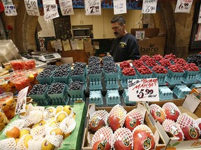 A vendor in Toronto's St. Lawrence Market shows off his produce. The cost of Statistics Canada's food basket rose 9.7 per cent in May from a year earlier.