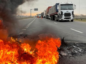 Trucks block a highway near a burning barricade in San Nicolas, Argentina as truck drivers protest against shortages and rising prices for diesel fuel, just as the country's crucial grains harvest requires transport amid surging inflation.