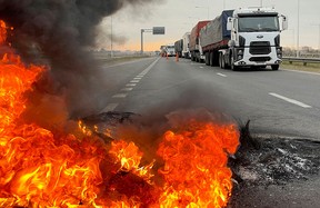 Trucks block a highway near a burning barricade in San Nicolas, Argentina as truck drivers protest against shortages and rising prices for diesel fuel, just as the country's crucial grains harvest requires transport amid surging inflation.