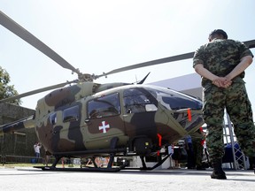 FILE - A Serbian Army officer stands by new Airbus H145M multi-utility helicopter during an arms fair in Belgrade, Serbia, Tuesday, June 25, 2019. Cyprus signed a deal with Airbus Helicopters on Friday, June 24, 2022 to purchase six light attack helicopters with an option for another six as it seeks to shed Soviet-era armaments and procure military equipment compatible with other European Union member states.