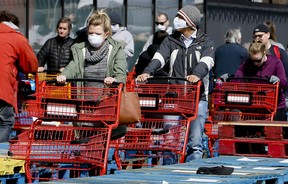 Due to COVID-19, shoppers line up in front of a Loblaws in Toronto in April, 2020 at the beginning of the pandemic. Grocery store workers were heralded as civic heroes for showing up to their jobs.