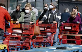 Aufgrund von COVID-19 stellen sich Käufer im April 2020 zu Beginn der Pandemie vor einem Loblaws in Toronto an.  Arbeiter in Lebensmittelgeschäften wurden als bürgerliche Helden gefeiert, weil sie zu ihrer Arbeit erschienen waren.