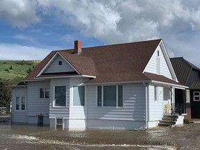 This photo provided by Katherine Schoolitz shows flood waters rise around a house in Red Lodge, Mont., on Monday, June 13, 2022. Raging floodwaters that pulled houses into rivers and forced rescues by air and boat began to slowly recede Tuesday across the Yellowstone region, leaving tourists and others stranded after roads and bridges were knocked out by torrential rains that swelled waterways to record levels. (Katherine Schoolitz via AP)
