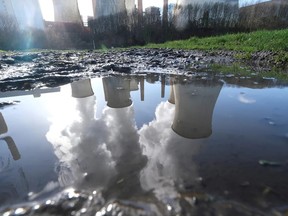 The lignite brown coal power plant complex of German energy supplier and utility RWE is reflected in a puddle in Neurath, north-west of Cologne, Germany.