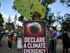 Demonstrators hold up placards outside the Australian Open venue during a climate protest rally in Melbourne.