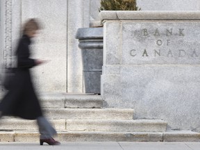A woman walks past the Bank of Canada building in Ottawa.