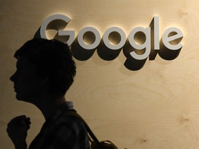 A woman passes the Google logo at the Arena Berlin in Berlin, Germany.