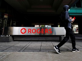 A person walks near the Rogers Communications building in Toronto.