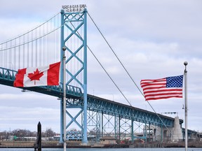 Canadian and American flags near the Ambassador Bridge at the Canada-U.S. border crossing in Windsor, Ont.
