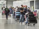 Reisende warten in der Warteschlange am Terminal 3 des Flughafens Toronto Pearson.