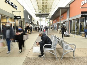 Les gens font leurs courses au centre commercial Toronto Premium Outlets à Milton, en Ontario, le vendredi 27 novembre 2020. Alors que de nombreux Canadiens n'ont plus peur de se rassembler et que les passeports pour les vaccins ont été abandonnés, les sociétés immobilières affirment que les chaînes de vente au détail et de restauration se démènent pour prendre de l'espace encore.