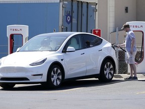 FILE - A Tesla owner charges his vehicle at a charging station in Topeka, Kan., Monday, April 5, 2021. Tesla reported 273 crashes involving partially automated driving systems, according to statistics released by U.S. safety regulators on Wednesday, June 15, 2022. But the National Highway Traffic Safety Administration cautioned against using the numbers to compare automakers, saying it didn't weigh them by the number of vehicles from each manufacturer that use the systems, or how many miles those vehicles traveled.