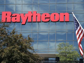 FILE - An American flag flies in front of the facade of Raytheon's Integrated Defense Systems facility, in Woburn, Mass on June 10, 2019. Aerospace and defense company Raytheon Technologies will establish a global headquarters in Arlington, Va.,, the company announced Tuesday, June 7, 2022.