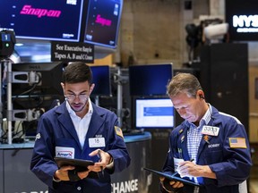 In this photo provided by the New York Stock Exchange, traders Orel Partush, left, and Robert Charmak work on the floor, Friday, June 10, 2022. Stocks on Wall Street fell sharply Friday after getting hammered by data showing inflation is getting worse, not better, as investors had been hoping.