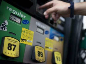 FILE - Wallace Reid purchases fuel for the vehicle he drives to make a living using ride-share apps, Wednesday, June 22, 2022, in the Queens borough of New York.