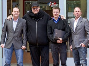 FILE - Megaupload founder Kim Dotcom, second left, stands with Bram van der Kolk, left, Mathias Ortmann and Finn Batato, right, outside the High Court in Auckland, New Zealand, Aug. 9, 2012. Ortmann and van der Kolk, charged by U.S. prosecutors for their involvement in the once wildly popular file-sharing website Megaupload, have pleaded guilty, Wednesday, June 22, 2022, to charges in New Zealand as part of a deal to avoid extradition to the U.S. The U.S. is still trying to extradite founder Kim Dotcom.