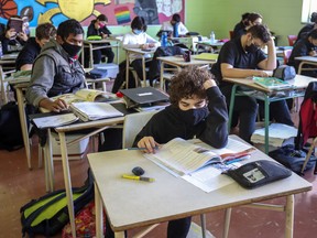 Masked students read at their desks in a school in Montreal.