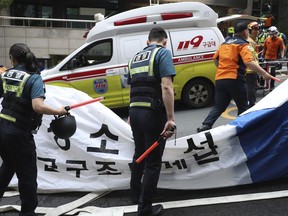 South Korean police officers and firefighters check around the scene of a fire in Daegu, South Korea, Thursday, June 9, 2022. Multiple people were killed and dozens of others were injured Thursday in the fire that spread through the office building in South Korea's Daegu city, local fire and police officials said.