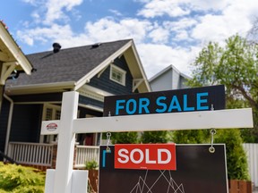 A for sale sign outside a home in Calgary.