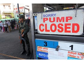 A member of Sri Lankan security personnel stands guard outside a fuel station that ran out of gasoline in Colombo on June 27, 2022.  Photographer: -/AFP/Getty Images