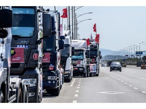 A car drives past line of parked trucks on a road outside a container port in Incheon on June 14, 2022, on the eighth day of protests over rising fuel costs that have further snarled global supply chains. Photographer: Anthony Wallace/AFP/Getty Images