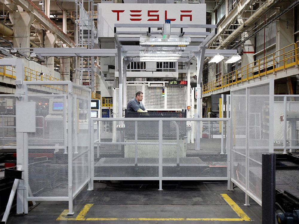 A worker watches a mechanical press line at the Tesla factory in Fremont, Calif.