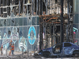 Local residents stand next to a building destroyed during Ukraine-Russia conflict in the city of Lysychansk in the Luhansk Region, Ukraine. Russia's war on Ukraine has been the economic "wild card" that has discouraged dealmaking.