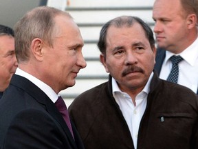 FILE - Nicaragua's President Daniel Ortega, right, and Russian President Vladimir Putin, left, attend a welcome ceremony at an airport in Managua, Nicaragua, July 11, 2014. The U.S. imposed sanctions Friday on Nicaragua's state-owned gold mining company, Empresa Nicaraguense de Minas, also known as ENIMINAS, along with the president of the firm's board of directors. The sanctions are imposed, in part, because the country's leaders are "deepening their relationship with Russia as it wages war against Ukraine, while using gold revenue to continue to oppress the people of Nicaragua," according to the Treasury Department.