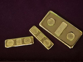 FILE - A customer puts gold bars in basket for to sell at a gold shop in Bangkok, Thailand, April 16, 2020. Russia appears to have defaulted on its foreign debt for the first time since the 1917 Bolshevik Revolution, and the U.S. and its allies are taking aim at the former Soviet Union's second-largest export industry after energy -- gold.
