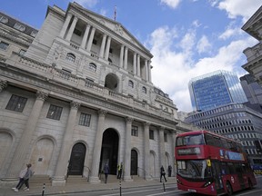 FILE - A bus drives past the Bank of England before the release of the Monetary Policy Report at the Bank of England in London, Thursday, May 5, 2022. The Bank of England is under pressure to raise interest rates more aggressively amid concern that the quarter-percentage-point hike expected Thursday will do little to combat price increases that have pushed inflation to a 40-year high.
