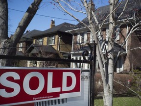A sold sign is shown in front of west-end Toronto homes Sunday, April 9, 2017. Royal LePage is cutting its expectations for the growth in home prices this year after it says prices in the second quarter fell compared with the first three months of the year.