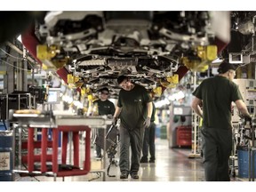 Employees work underneath Jaguar automobiles on the final assembly line at Tata Motors Ltd.'s Jaguar assembly plant in Castle Bromwich, U.K., on Thursday, March 16, 2017. Jaguar Land Rover Chief Executive Officer Ralf Speth backed Nissan Motor Co.'s calls for extra funding for car-parts makers in the wake of last years Brexit vote, while cautioning that there must be "fair play" for all U.K. automakers. Photographer: Simon Dawson/Bloomberg