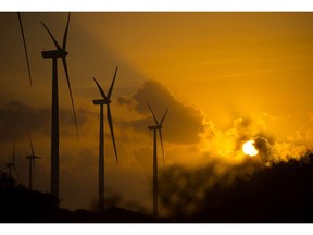 Wind turbines stand during sunset at the Avangrid Renewables' Baffin Wind Power Project in Sarita, Texas, U.S., on Wednesday, June 14, 2017. In the cut-throat Texas energy market, the construction of coastal wind turbines--some 900 in all--has had a profound impact. It's been terrific for consumers, helping further drive down electricity bills, but horrible for natural gas-fired generators.