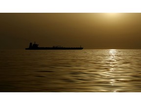 An oil tanker is silhouetted against the hazy sky. Photographer: Marcelo del Pozo/Bloomberg