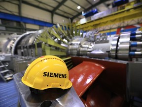A Siemens branded yellow hard hat sits inside a Siemens AG gas turbine factory in Berlin, Germany, on Wednesday, Dec. 4, 2019. Siemens AG aims to shed about 75% of its struggling power and gas unit in one of the most radical moves to date by Chief Executive Officer Joe Kaeser to untangle the sprawling conglomerate and try to boost its valuation. Photographer: Krisztian Bocsi/Bloomberg