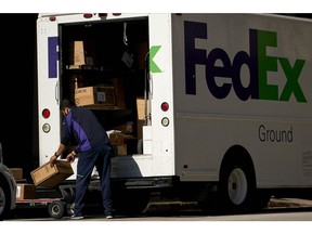 A FedEx Corp. worker wearing a protective mask unloads a truck in downtown Dallas, Texas, U.S., on Wednesday, May 27, 2020. Texas Governor Greg Abbott allowed bars--along with rodeos, bowling alleys and bingo halls--to open their doors at reduced capacity in the second phase of the state's plan to restart the economy after shutting down in early April to slow the coronavirus. Photographer: Cooper Neill/Bloomberg