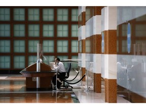 A security guard sits behind plexiglass at Brookfield Place in the financial district of Toronto, Ontario, Canada, on Friday, May 22, 2020. Whether the PATH, a subterranean network that provides connections between major commuter stations, over 80 properties, including the headquarters of Canada's five largest banks, and 1,200 retail spots, can return to its glory days will depend initially on how quickly Bay St. firms return workers to their offices.