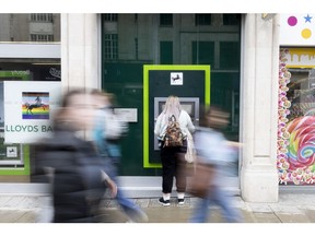 A customer uses an automated teller machine (ATM) outside a Lloyds Banking Group Plc bank branch in London, U.K., on Monday, June 28, 2021. The U.K. ranked as the worlds second-largest financial center, after the U.S., according to analysis by think tank New Financial.