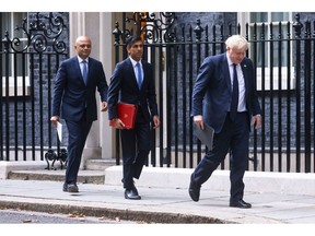 Boris Johnson, U.K. prime minister, right, Rishi Sunak, U.K. chancellor of the exchequer, center, and Sajid Javid, U.K. health secretary, depart from number 10 Downing Street ahead of a news conference in London, U.K., on Tuesday, Sept. 7, 2021. Johnson announced a tax hike on workers, businesses and shareholders to help rescue the National Health Service from soaring backlogs that built up during the Covid-19 pandemic and reform the "broken" social care system.